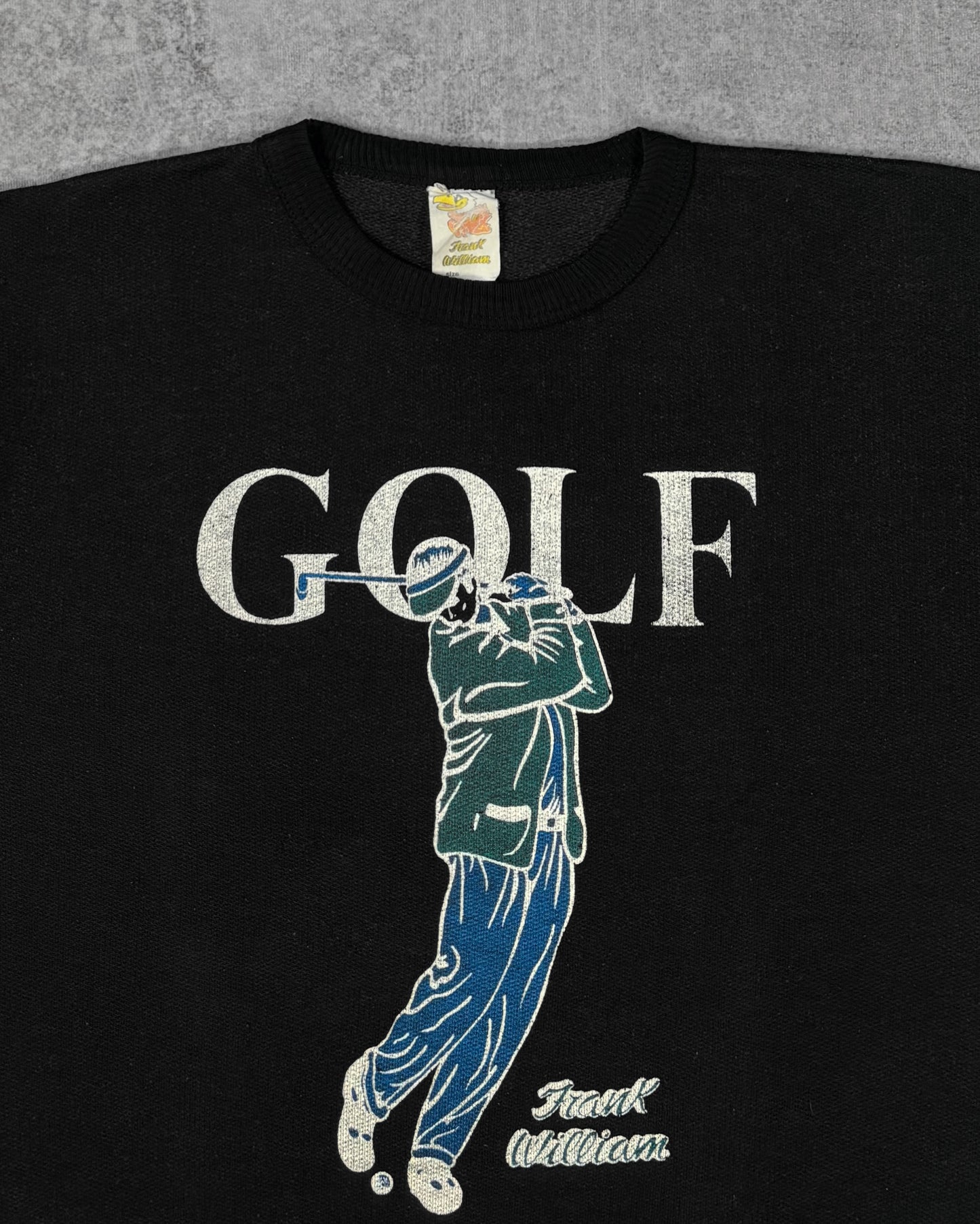 Close-up print detail of the screen-printed golfer graphic and 'GOLF' lettering on the Frank William crewneck sweatshirt